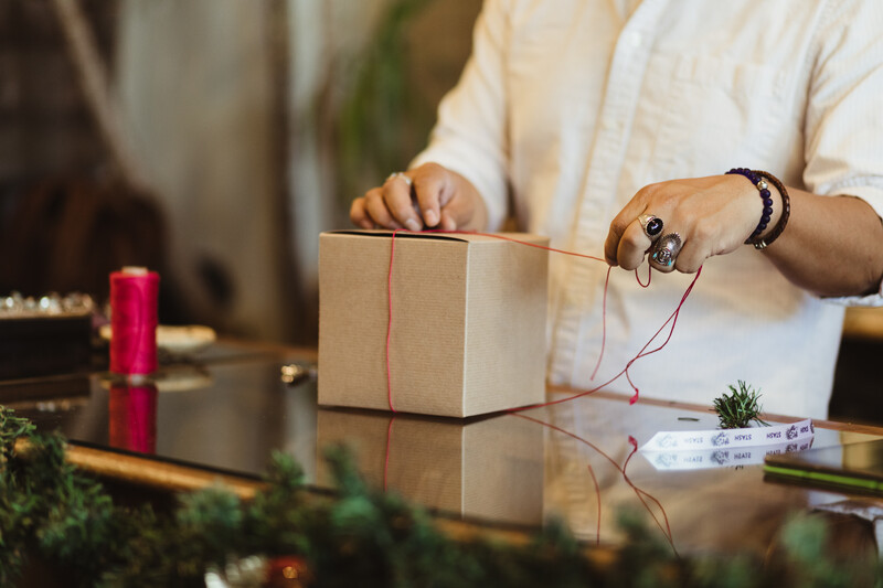 A retailer wraps a subscription box for a customer