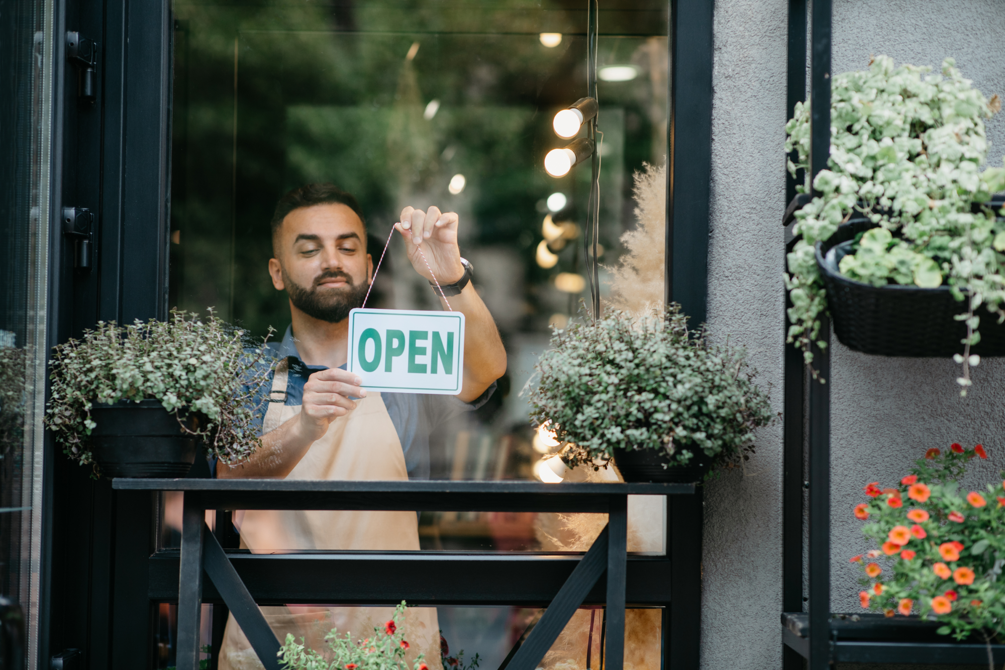 A shop owner turns the open sign in his window